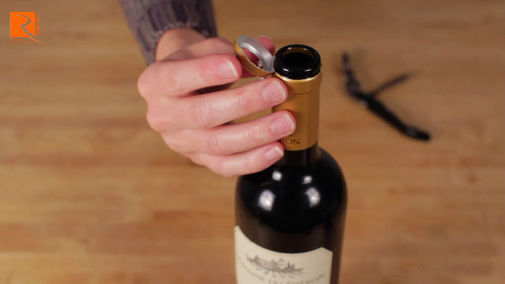 Dùng khui mở rượu để bẩy miếng gỗ sồi ở cổ chai ra.
